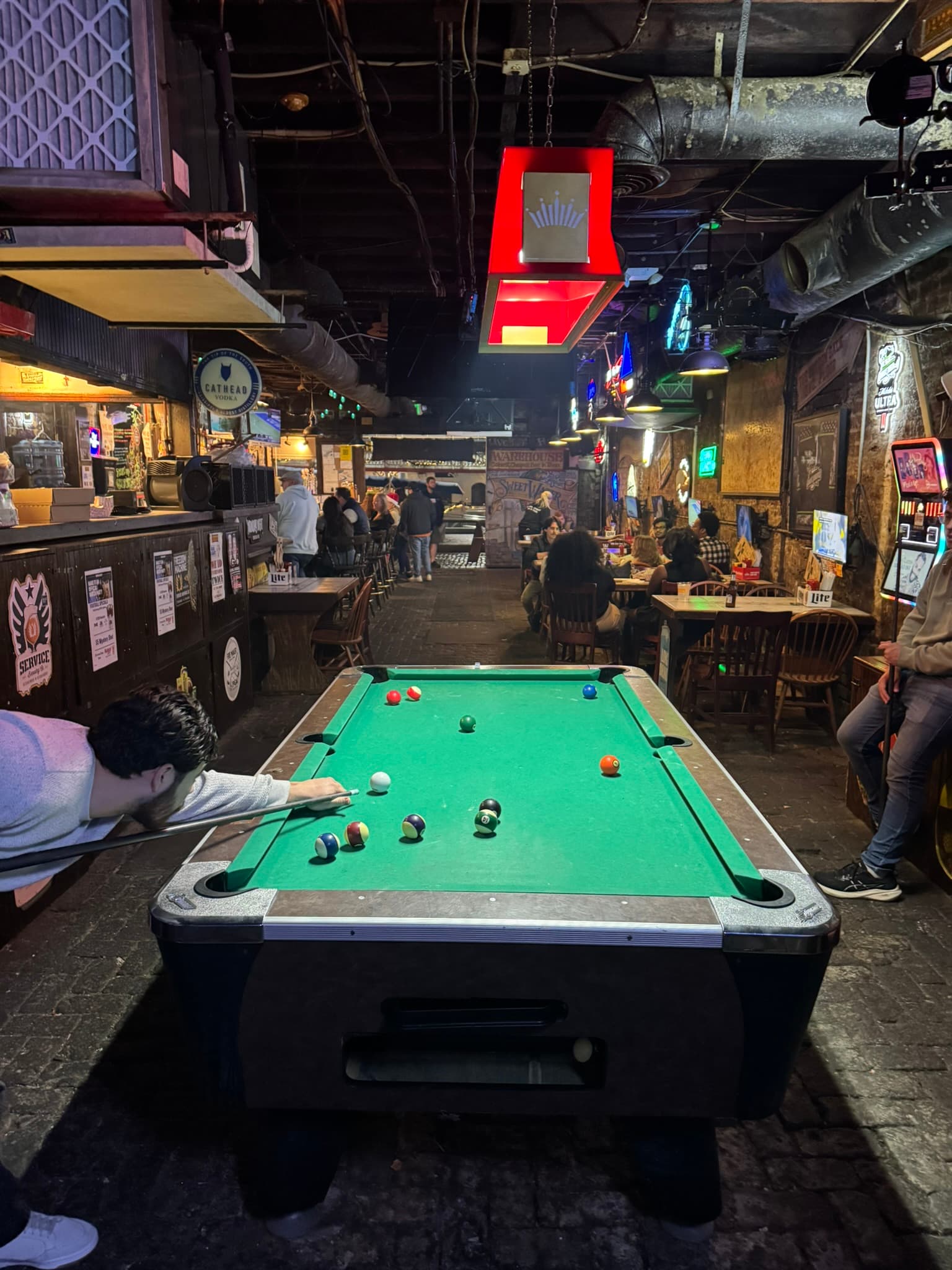 Pool table in a bar with players lining up shots